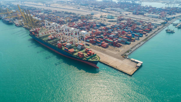 istock Container ship in export and import business and logistics. Shipping cargo to harbor by crane. Water transport International. Aerial view and top view. 1014270184