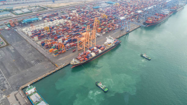 istock Container ship in export and import business and logistics. Shipping cargo to harbor by crane. Water transport International. Aerial view and top view. 1014270262