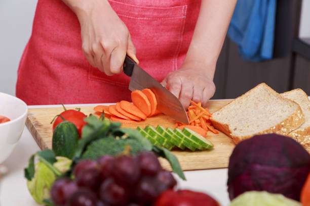 istock hand cutting carrot on board in kitchen room 1014271382