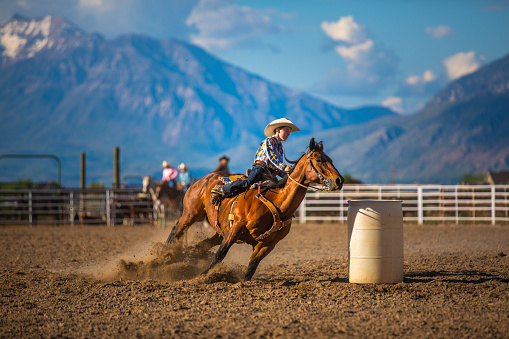 Young cowboy barrel racing at a local rodeo arena