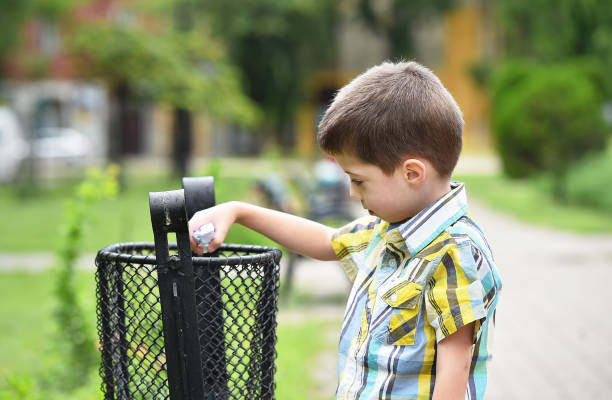 little boy throwing garbage outdoor