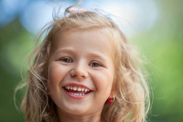 istock Smiling cute little girl on green background 1014272498