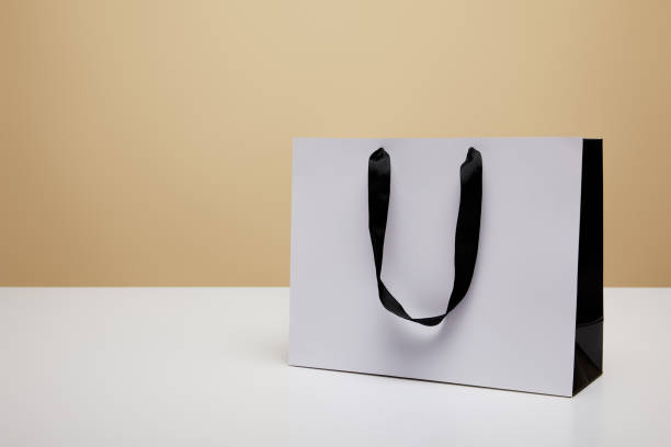 istock one white shopping bag on white table isolated on beige 1014276358