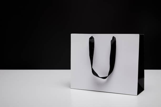 istock one white paper shopping bag on white table isolated on black 1014276976
