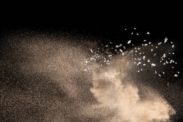 istock Golden sand with stone explosion isolated on black background. Abstract sand cloud. 1014287786