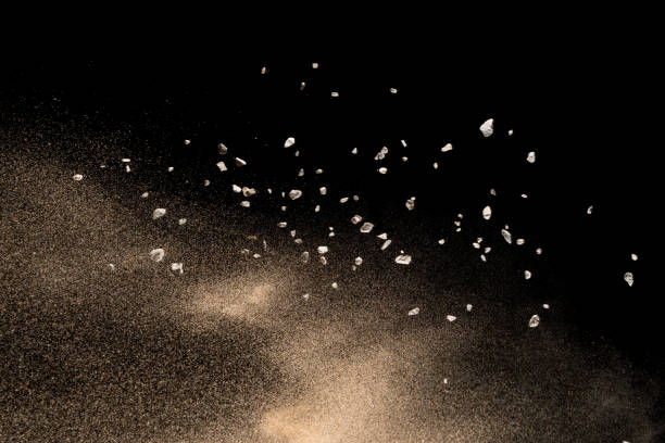 istock Golden sand with stone explosion isolated on black background. Abstract sand cloud. 1014287840
