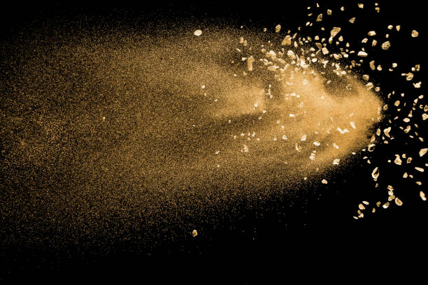 istock Golden sand with stone explosion isolated on black background. Abstract sand cloud. 1014287874