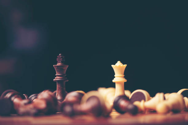istock Chess pieces on the board. Black wood background behind. 1014291896