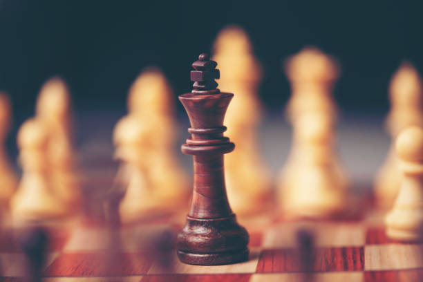 istock Chess pieces on the board. Black wood background behind. 1014291898