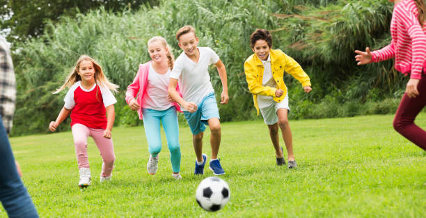 istock Kids playing football in park 1014298388
