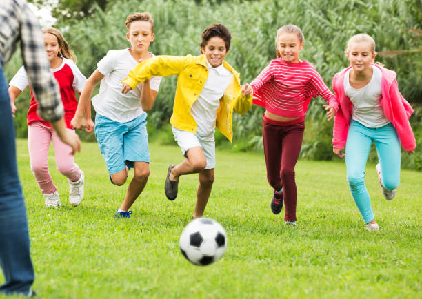 istock Kids playing football in park 1014298438