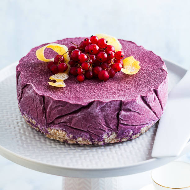 frozen blueberry lemon cake from ice cream and fresh berries on a cake stand on a marble table. summer festive dessert