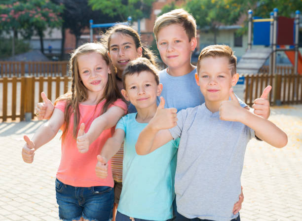 istock Glad kids posing at the playground and thumbs up 1014308470