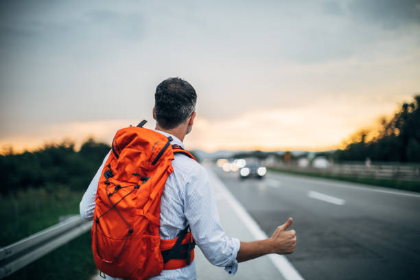 istock Man hitchhiking by the road 1014312236