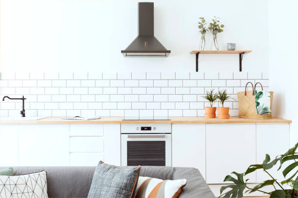 istock Stylish scandinavian open space with kitchen accessories, plants. Design room with white brick walls. 1014313128