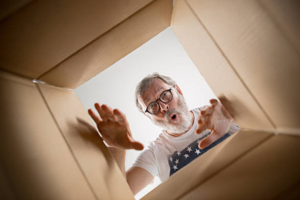 istock Man unpacking and opening carton box and looking inside 1014317468