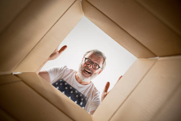 istock Man unpacking and opening carton box and looking inside 1014317580
