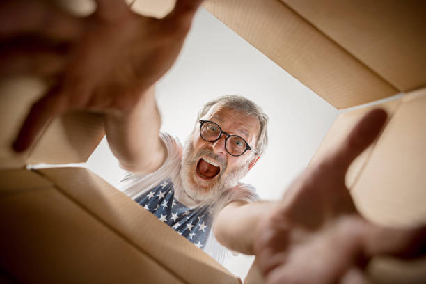 istock Man unpacking and opening carton box and looking inside 1014317830