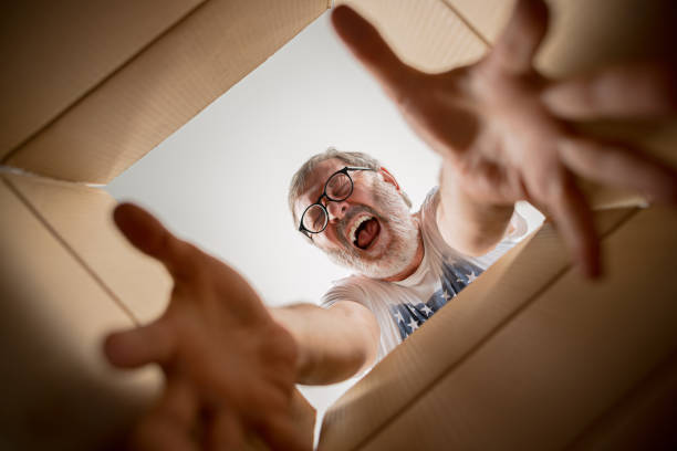 istock Man unpacking and opening carton box and looking inside 1014318358