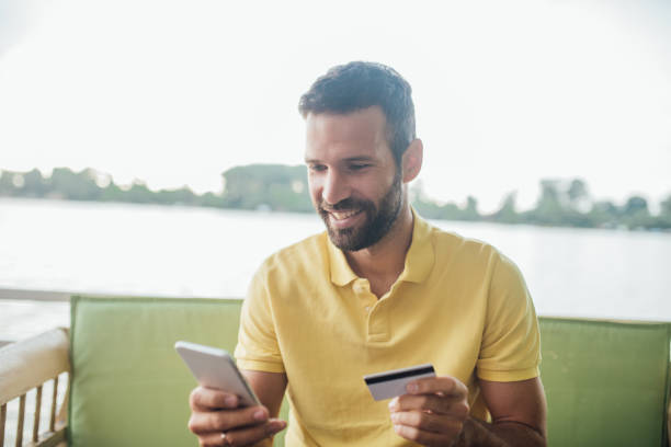 istock Smiling young man shopping online 1014332242