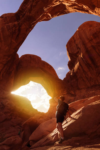 istock Female hiker watching sunset through Double O Arch 1014339168