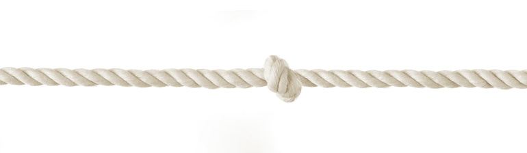 Braided white rope and knot in the middle isolated on white background. difficulty concept