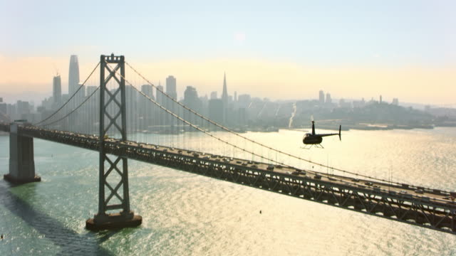 AERIAL Helicopter flying along the San Francisco-Oakland Bay Bridge in San Francisco, CA