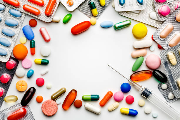 Health themes. Large group of assorted capsules, pills and blisters making a frame on white background. Space for text.