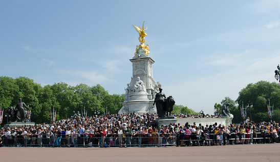 London/UK May 21 2018: People gathered outside Buckingham Palace for the changing of guards parade. Statue of Queen Victoria in the background