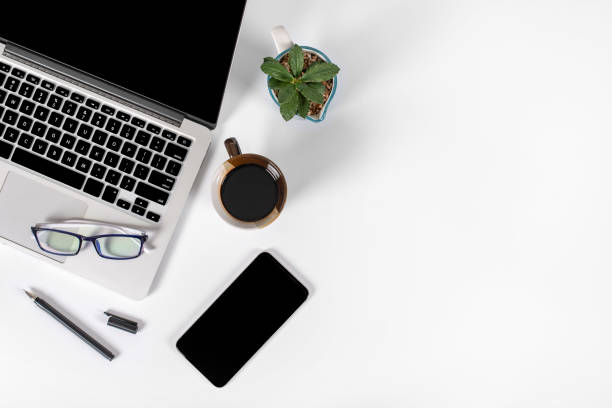 istock Office table with laptop computer, smartphone, pen, notebook and coffee on isolated pure white background / Laptop and tablet mockup concept. (Selective Focus) 1014354854