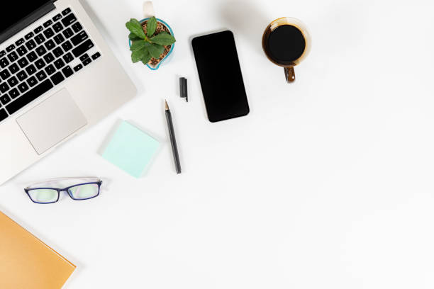 istock Office table with laptop computer, smartphone, pen, notebook and coffee on isolated pure white background / Laptop and tablet mockup concept. (Selective Focus) 1014354924