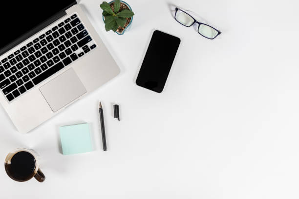 istock Office table with laptop computer, smartphone, pen, notebook and coffee on isolated pure white background / Laptop and tablet mockup concept. (Selective Focus) 1014356970