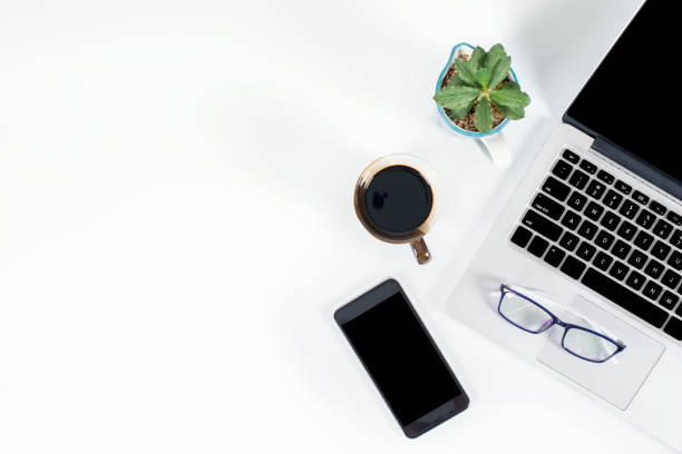 istock Office table with laptop computer, smartphone, pen, notebook and coffee on isolated pure white background / Laptop and tablet mockup concept. (Selective Focus) 1014357008