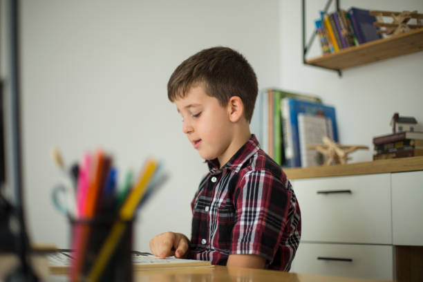 istock Little boy doing homework at home 1014365312
