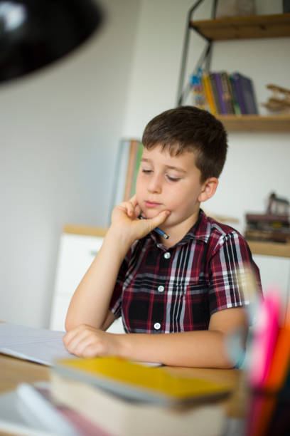 istock Little boy doing homework at home 1014367858