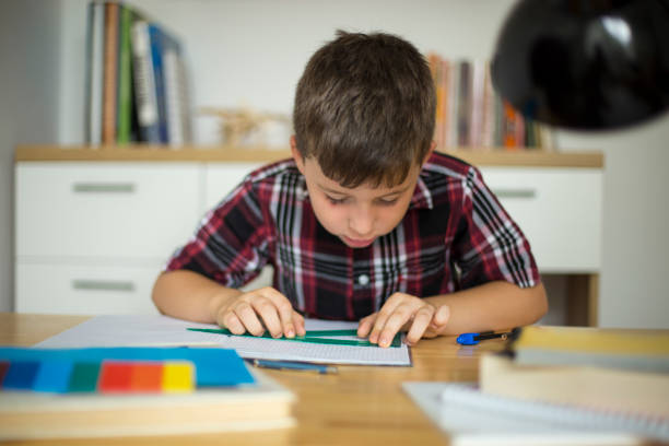istock Little boy doing homework at home 1014368518