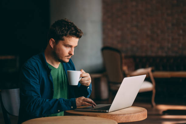 istock Young Man Working on Laptop and Drinking Coffee 1014374806