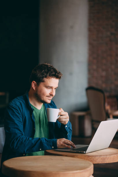 istock Young Man Working on Laptop and Drinking Coffee 1014374912