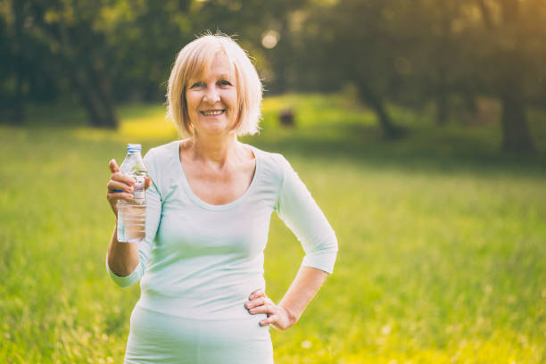 istock Sporty senior woman drinking water 1014385892