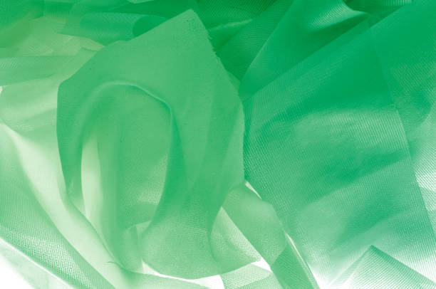 istock Texture, background, pattern. The texture of the silk fabric is green. Silk fabric is transparent. Fabric or liquid wave illustration of wavy creases of silk satin texture or velvet material 1014386466