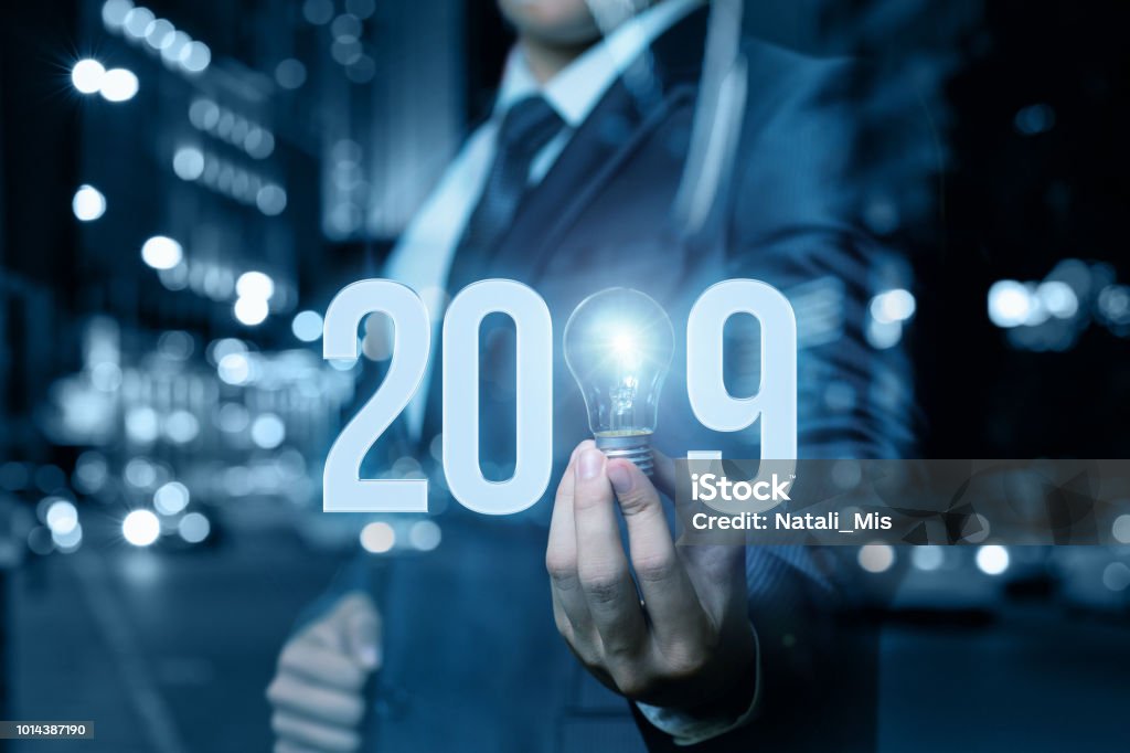 2019 new business ideas. 2019 Ideas concepts with business man hand holding light bulb. Forecasting Stock Photo