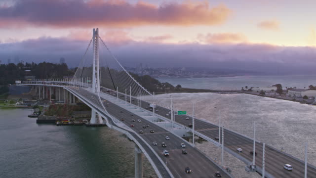 AERIAL San Francisco-Oakland Bay Bridge towards the Yerba Buena Island at sunset