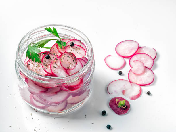 istock Radish sliced in pieces lying in a glass jar on a white background 1014392488