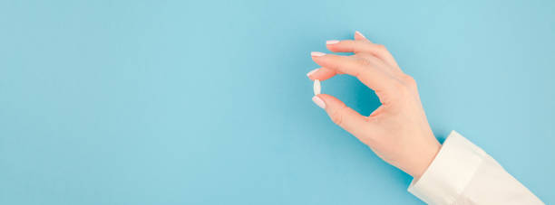 istock Female hand holding a white pill 1014413032