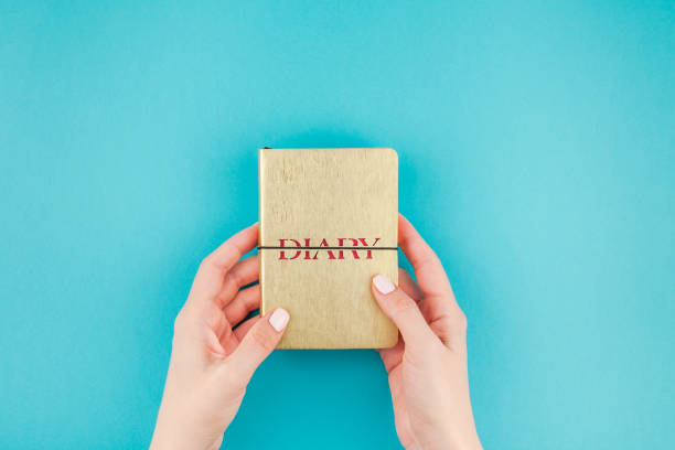 istock Woman hands holding golden diary 1014413216