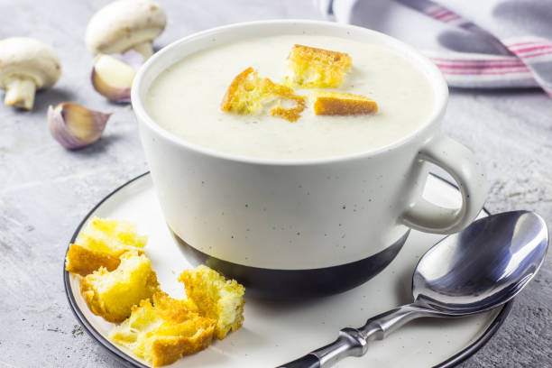 istock mushroom cream soup on white wooden board. top view 1014413420