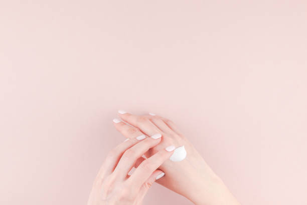 Woman moisturizing her hand with cosmetic cream
