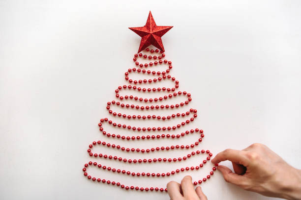 una persona hace un creativo árbol de navidad o año nuevo de granos en un estilo minimalistico y adorna con una estrella - mano sobre cadera fotografías e imágenes de stock