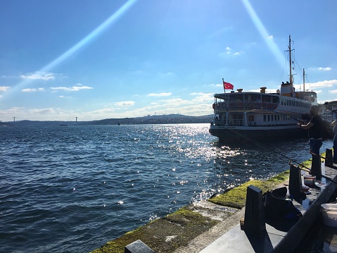 Eminonu, Istanbul, Turkey - June 3, 2018: People are fishing just near by the ferry terminal.