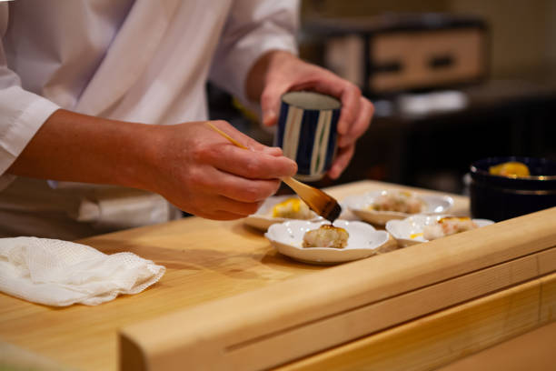 istock Professional and experienced sushi chef carefully add final touch with confident and dedication to his perfect sushi. 1014436448
